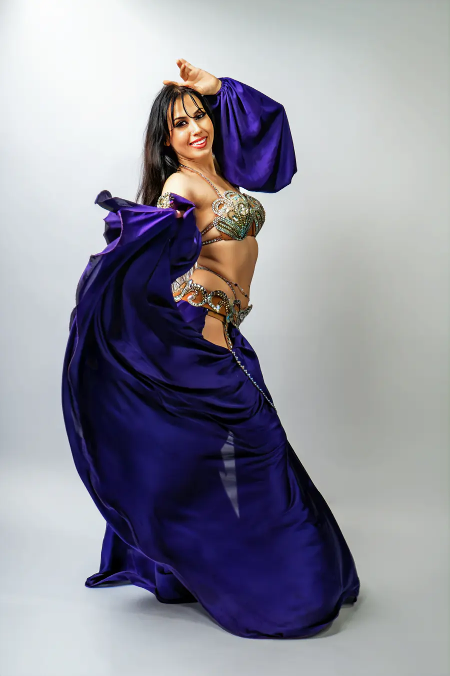 Belly dancer Azeeria Azizah smiling as her purple skirt swirls around her